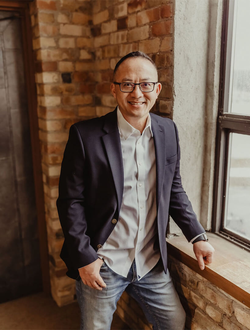 Blong Yang smiling next to a window